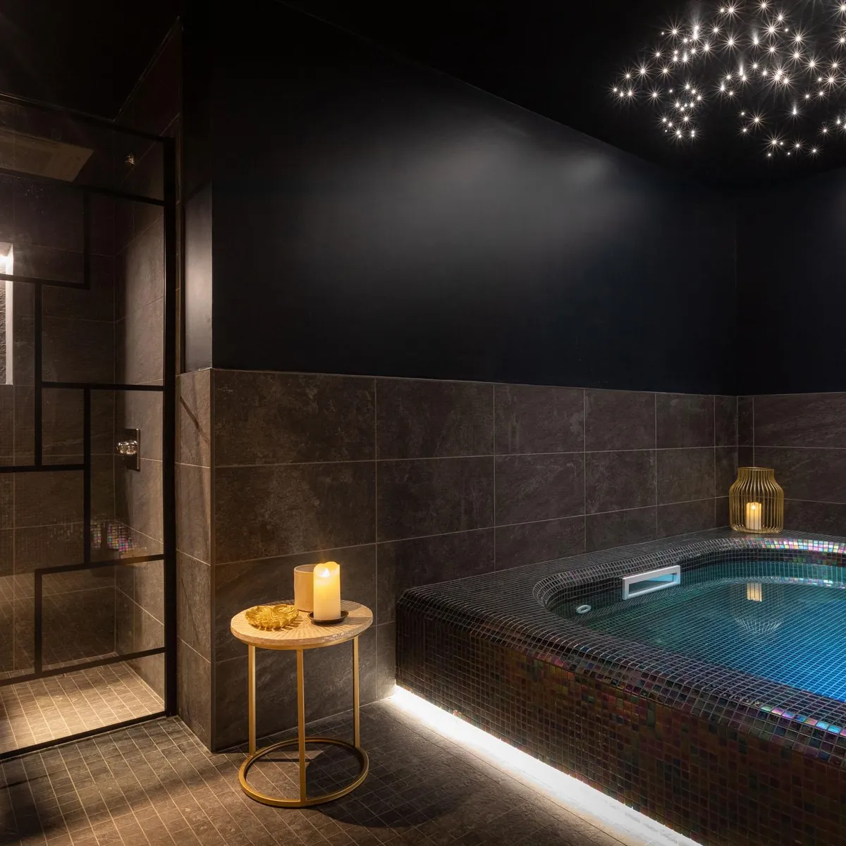 Salle de bain luxueuse avec baignoire encastrée, bougies et éclairage étoilé au plafond