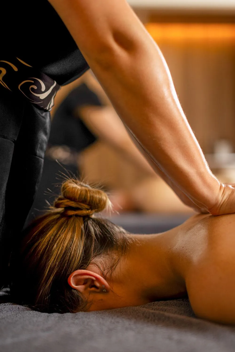 Une personne allongée sur le ventre reçoit un massage sur le dos
